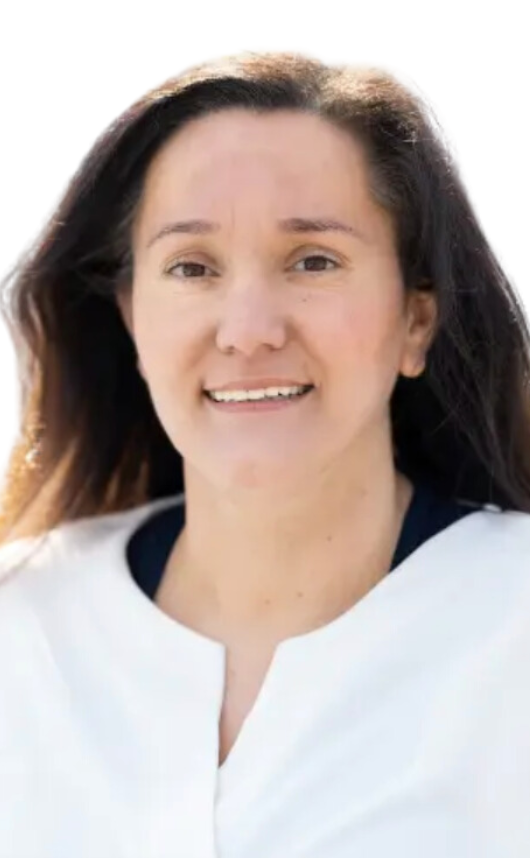 Person mit weißem Oberteil, dunklem Haar und neutralem Hintergrund.